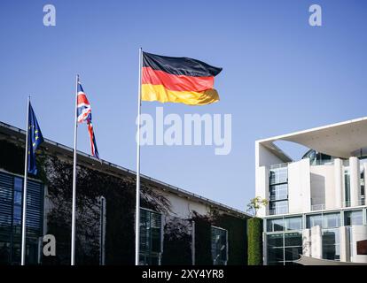 Die Fahne Europas, die des Vereinigten Koenigreichs Grossbritannien und Nordirland und die der Bundesrepublik Deutschland wehen im Wind vor dem Bundeskanzleramt in Berlin, anlaesslich des Besuchs von Premierminister des Vereinigten Koenigreichs Grossbritannien, 28.08.2024. Berlin Deutschland *** le drapeau de l'Europe, le drapeau du Royaume-Uni de Grande-Bretagne et d'Irlande du Nord et le drapeau de la République fédérale d'Allemagne agitent au vent devant la Chancellerie fédérale à Berlin, à l'occasion de la visite du premier ministre du Royaume-Uni de Grande-Bretagne, 28 08 2024 Banque D'Images