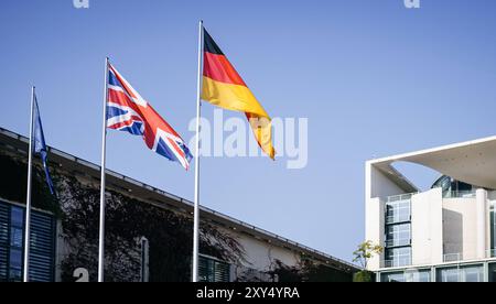 Die Fahne Europas, die des Vereinigten Koenigreichs Grossbritannien und Nordirland und die der Bundesrepublik Deutschland wehen im Wind vor dem Bundeskanzleramt in Berlin, anlaesslich des Besuchs von Premierminister des Vereinigten Koenigreichs Grossbritannien, 28.08.2024. Berlin Deutschland *** le drapeau de l'Europe, le drapeau du Royaume-Uni de Grande-Bretagne et d'Irlande du Nord et le drapeau de la République fédérale d'Allemagne agitent au vent devant la Chancellerie fédérale à Berlin, à l'occasion de la visite du premier ministre du Royaume-Uni de Grande-Bretagne, 28 08 2024 Banque D'Images