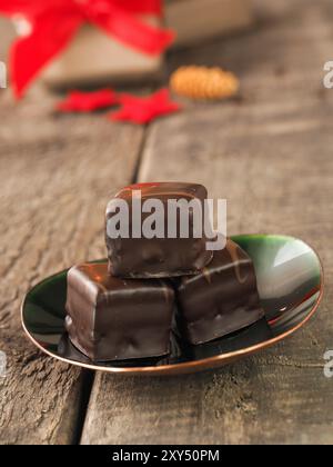 Moelleux au chocolat savoureux dés sur une plaque verte, boulangerie pâtisserie de Noël ou concept, coffrets cadeaux et décoration de Noël dans l'arrière-plan Banque D'Images