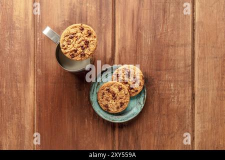 Cookies aux pépites de chocolat, tourné par le haut sur un fond de bois rustique foncé avec du lait et un lieu pour le texte Banque D'Images