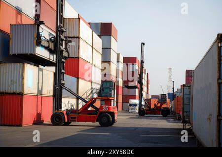 Chariot élévateur de conteneur dans la cour d'expédition avec pile de conteneurs colorés, fond d'espace de copie, logistique, importation, cargaison d'exportation, fret avant guerre Banque D'Images