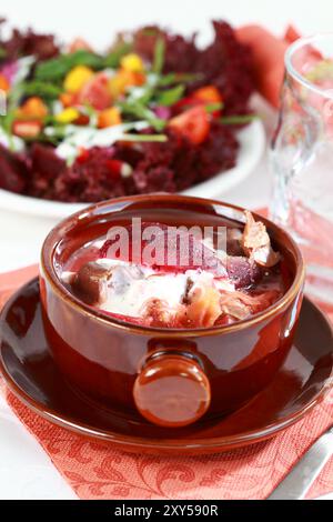 Soupe de chou rouge avec betterave (borscht) plat national russe avec salade de légumes en arrière-plan Banque D'Images