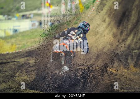 Motocross pilote prend un run-up devant la colline de saut Banque D'Images