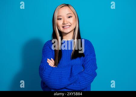 Photo portrait de cheveux teints jeune fille vietnamienne pliée mains satisfaites sourire semble confiant isolé sur fond de couleur bleue Banque D'Images