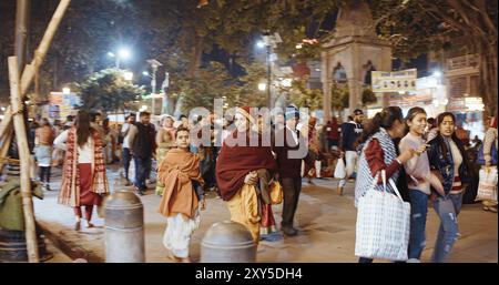 Varanasi, Uttar Pradesh, Inde - 8 février 2024 : enfants indiens marchant dans la foule dans la rue animée de nuit Banque D'Images