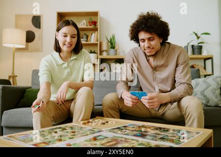 Joyeux jeune couple jouant au jeu de table Banque D'Images