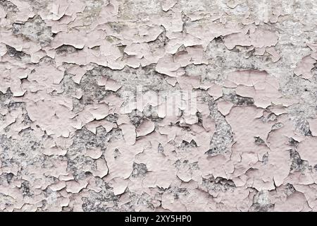 Revêtement de peinture rose avec des fissures sur une pierre grise sale. Peeling peinture rose Grunge dans un style vintage Banque D'Images