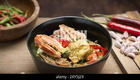 Une délicieuse cuisine thaïlandaise crabe sauté au cari jaune sur le sol en bois Banque D'Images