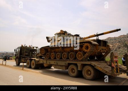 Dlib, Syrie. 10 mars 2020. Un convoi turc de véhicules militaires entre en Syrie par le terminal de Kafr Lusin situé près du terminal de Bab Al-Hawa dans le nord d'Idlib. La colonne s’est dirigée vers les postes d’observation turcs situés dans la zone de « désescalade » à Idlib pour renforcer un grand nombre de véhicules militaires turcs et de soldats déployés dans la région ces dernières semaines. La Turquie a continué d’envoyer davantage de renforts militaires dans la zone de « désescalade » depuis que le nouveau cessez-le-feu dans la région est entré en vigueur vendredi dernier, à la suite d’une réunion de six heures entre le président russe Poutine et son turc Banque D'Images