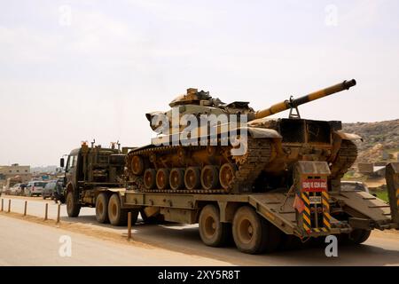 Dlib, Syrie. 10 mars 2020. Un convoi turc de véhicules militaires entre en Syrie par le terminal de Kafr Lusin situé près du terminal de Bab Al-Hawa dans le nord d'Idlib. La colonne s’est dirigée vers les postes d’observation turcs situés dans la zone de « désescalade » à Idlib pour renforcer un grand nombre de véhicules militaires turcs et de soldats déployés dans la région ces dernières semaines. La Turquie a continué d’envoyer davantage de renforts militaires dans la zone de « désescalade » depuis que le nouveau cessez-le-feu dans la région est entré en vigueur vendredi dernier, à la suite d’une réunion de six heures entre le président russe Poutine et son turc Banque D'Images