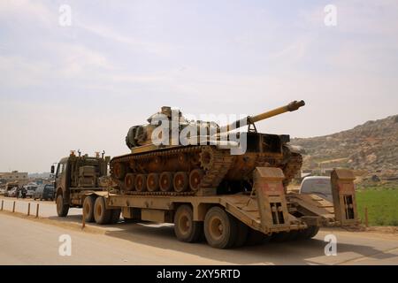 Dlib, Syrie. 10 mars 2020. Un convoi turc de véhicules militaires entre en Syrie par le terminal de Kafr Lusin situé près du terminal de Bab Al-Hawa dans le nord d'Idlib. La colonne s’est dirigée vers les postes d’observation turcs situés dans la zone de « désescalade » à Idlib pour renforcer un grand nombre de véhicules militaires turcs et de soldats déployés dans la région ces dernières semaines. La Turquie a continué d’envoyer davantage de renforts militaires dans la zone de « désescalade » depuis que le nouveau cessez-le-feu dans la région est entré en vigueur vendredi dernier, à la suite d’une réunion de six heures entre le président russe Poutine et son turc Banque D'Images