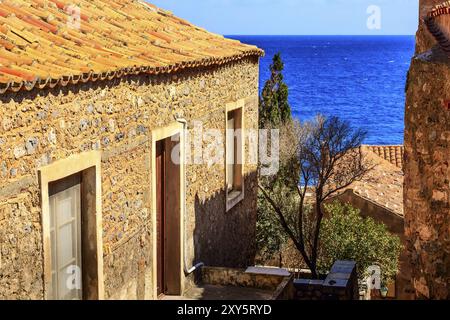 Vue sur la rue Monemvasia avec maisons anciennes, toits dans la ville antique et vue sur la mer, Péloponnèse, Grèce, Europe Banque D'Images