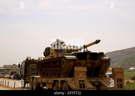 Dlib, Syrie. 10 mars 2020. Un convoi turc de véhicules militaires entre en Syrie par le terminal de Kafr Lusin situé près du terminal de Bab Al-Hawa dans le nord d'Idlib. La colonne s’est dirigée vers les postes d’observation turcs situés dans la zone de « désescalade » à Idlib pour renforcer un grand nombre de véhicules militaires turcs et de soldats déployés dans la région ces dernières semaines. La Turquie a continué d’envoyer davantage de renforts militaires dans la zone de « désescalade » depuis que le nouveau cessez-le-feu dans la région est entré en vigueur vendredi dernier, à la suite d’une réunion de six heures entre le président russe Poutine et son turc Banque D'Images