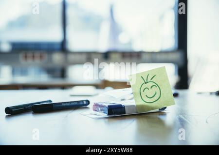 Smiley illustration à la place de travail, atelier. Stylos et fenêtre dans l'arrière-plan flou Banque D'Images