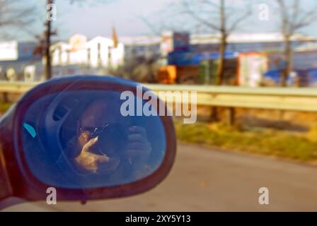 Reflet d'un photographe dans le rétroviseur latéral d'une voiture Banque D'Images