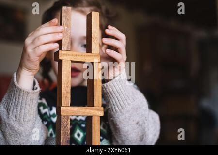 Gros plan fille équilibrant des blocs de bois empilés Banque D'Images