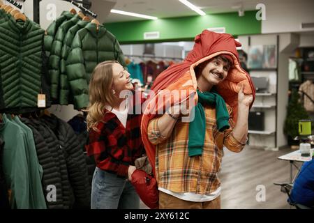 Homme et femme ravis de magasiner à la boutique de vêtements de sport Banque D'Images