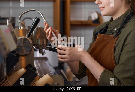 Gros plan du barista préparant un latte avec de la mousse de lait sur la machine à café Banque D'Images