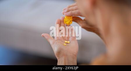 Femme âgée versant des pilules de bouteille pour les médicaments quotidiens Banque D'Images