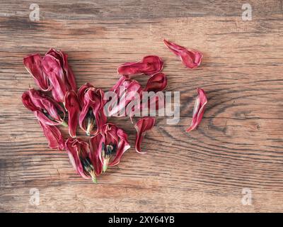 Forme de coeur de pétales de tulipes séchées sur une table en bois rustique en utilisant comme fond Banque D'Images