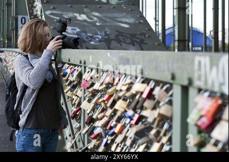 Jeune femme avec caméra au pont Hohenzollern à Cologne Banque D'Images