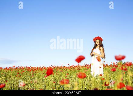 Young happy smiling woman in champ de coquelicots Banque D'Images