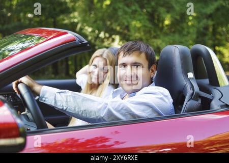 Heureux couple red cabriolet dans une journée ensoleillée Banque D'Images