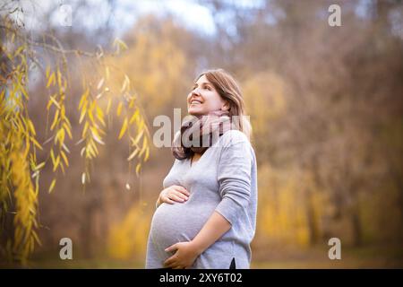 Happy young pregnant woman in autumn park Banque D'Images