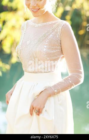 Belle bride standing par le lac au coucher du soleil. Close up Banque D'Images