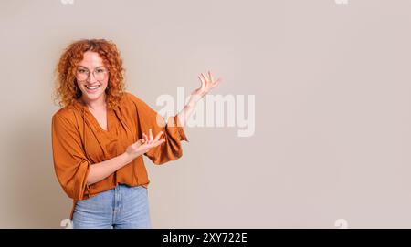 Portrait de jeune vendeuse souriante et présentant le nouveau produit sur l'espace de copie sur fond blanc Banque D'Images