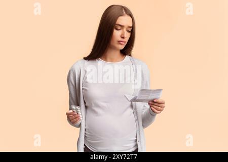 Dame enceinte l'enseignement de la lecture pour les comprimés debout, Studio Shot Banque D'Images