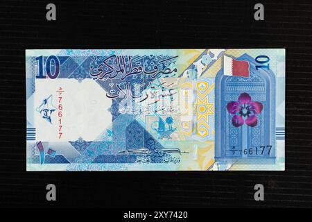 Drapeau du Qatar, fleur de rêve et une porte représentant l'architecture qatarienne historique, portrait du billet de banque qatari de 10 riyal 2020. Banque D'Images