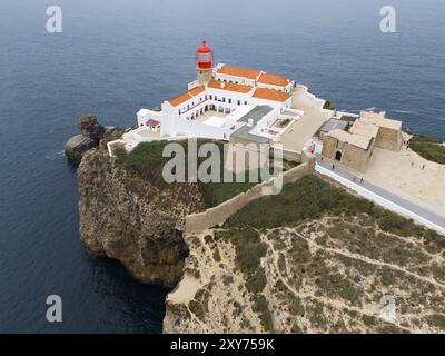 Un phare rouge sur une falaise au-dessus de l'océan, entouré de bâtiments blancs et un paysage pittoresque, vue aérienne, phare, Cabo de Sao Vicente, Banque D'Images