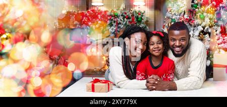 Famille de trois afro amour lying on floor near Christmas Tree Banque D'Images