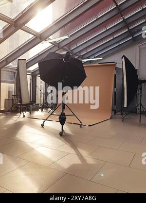 Divers éclairs et lampes professionnels placés dans un studio de photographie moderne pendant la journée Banque D'Images