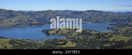 Port et montagnes d'Akaroa. Paysage sur la péninsule de Banks, Nouvelle-Zélande. Baie, ville, terres agricoles et montagnes Banque D'Images