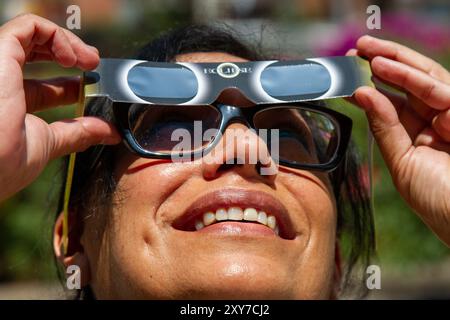 Mexico, Mexique ; 04 08 2024 ; Une femme regardant l'éclipse solaire totale avec une paire de lunettes solaires. Banque D'Images