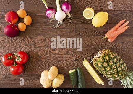 Différents fruits et légumes crus sur un fond de bois Banque D'Images