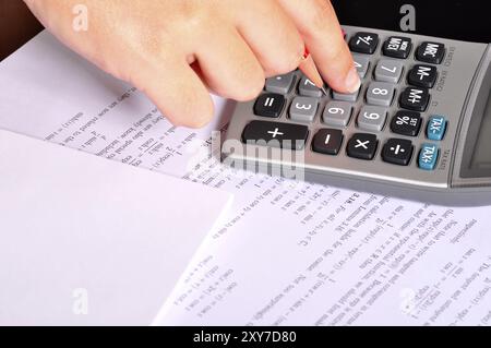 Étudiant faisant des exercices de mathématiques avec une calculatrice et un crayon rouge Banque D'Images