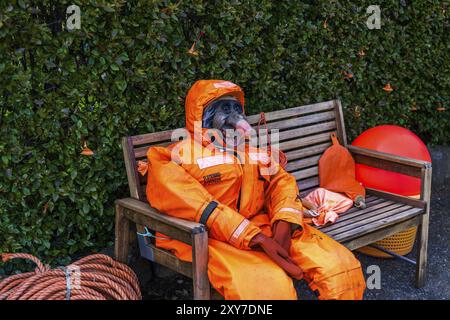 DJUPIVOGUR, ISLANDE, 21 JUIN : mannequin d'une sorcière au visage laid et effrayant dans une combinaison orange est assis sur un banc en bois le 21 juin 2013 à Djupivogur, Banque D'Images