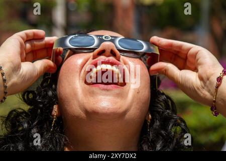 Mexico, Mexique ; 04 08 2024 ; Une femme regardant l'éclipse solaire totale avec une paire de lunettes solaires. Banque D'Images