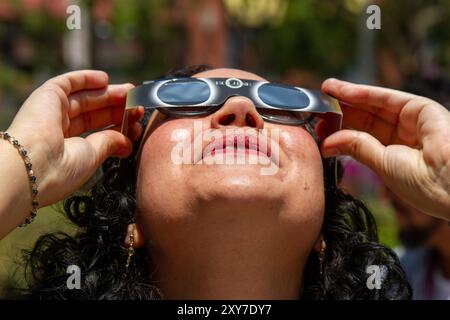 Mexico, Mexique ; 04 08 2024 ; Une femme regardant l'éclipse solaire totale avec une paire de lunettes solaires. Banque D'Images