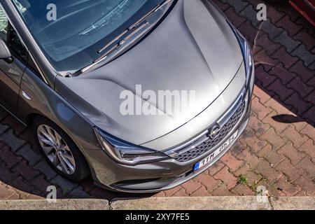 OSTRAVA, TCHÉQUIE - 6 AOÛT 2024 : partie avant d'une Opel Astra K à hayon argenté avec calandre et badge Banque D'Images