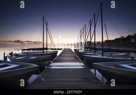 Jetée et yacht sur le lac au lever du soleil, pays-Bas Banque D'Images