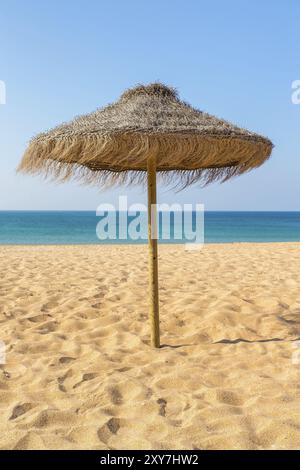 Un parasol de plage en chaume du blue sea au portugal Banque D'Images