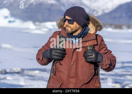 Portrait d'un randonneur marchant sur le lac gelé du glacier Jokulsarlon en Islande Banque D'Images