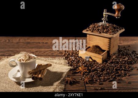 Tasse de café avec de la crème fouettée et rectifieuse de café sur un fond de bois Banque D'Images