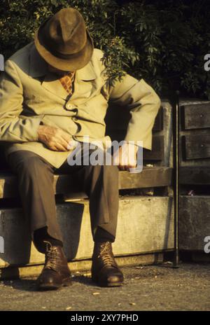 Vieil homme sur un banc de parc Banque D'Images