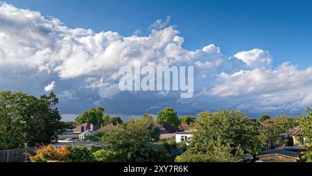 De grands cumulonimbus se forment au-dessus d'un paysage urbain rural Banque D'Images