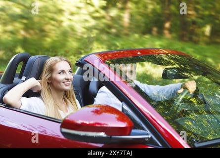 Heureux couple red cabriolet dans une journée ensoleillée Banque D'Images